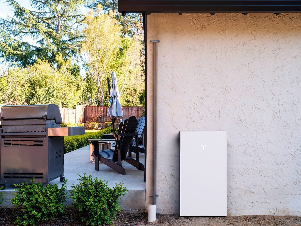 Home battery backup unit installed beside a residential patio